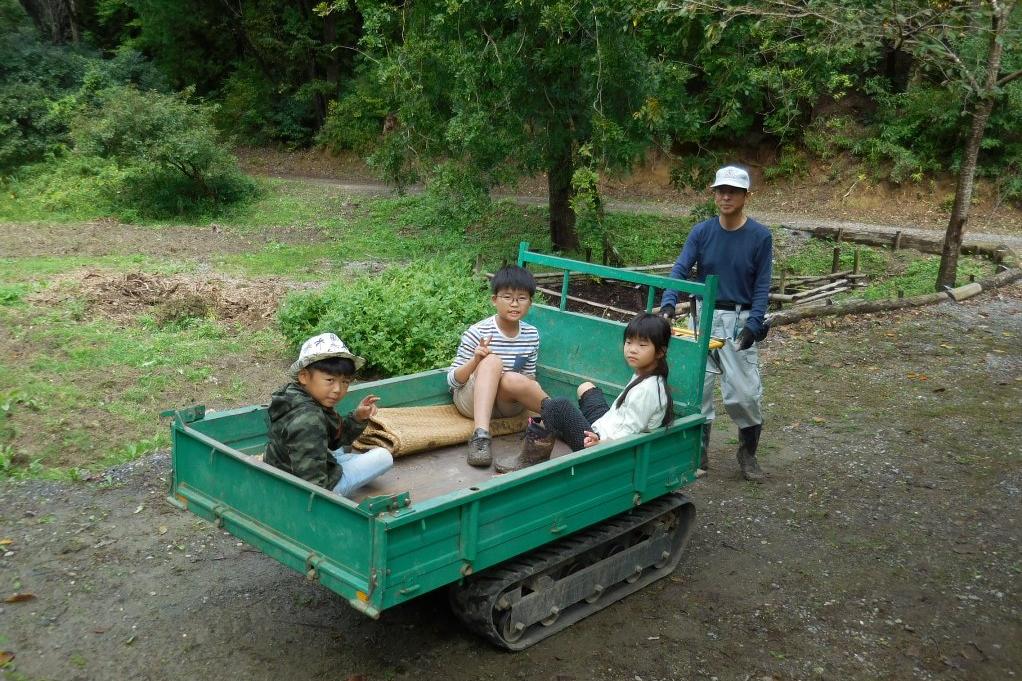 荷物運搬車に乗る子供たち