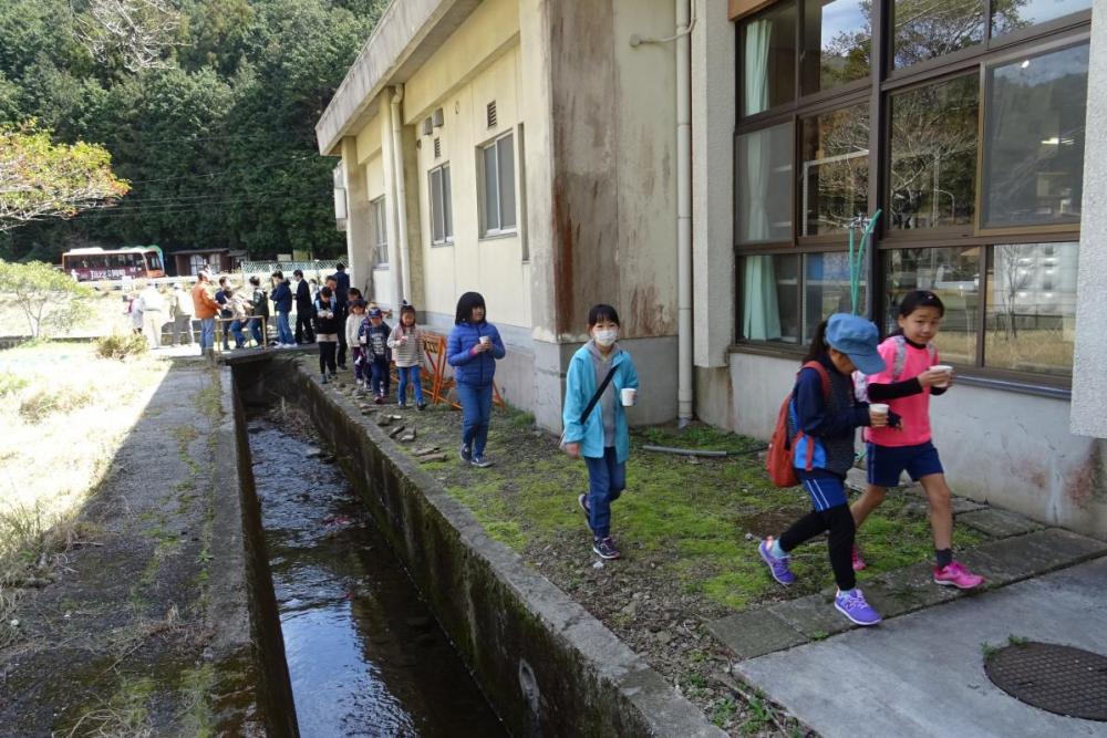 カップを受け取り川へ向かう児童たち