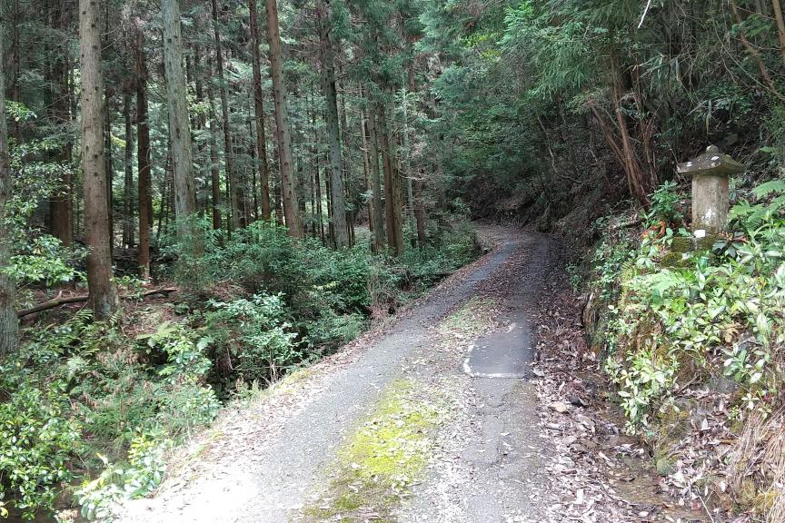 右手の石塔が見えたらまだルートの半分地点。この後も1.3㎞極狭道が続きます