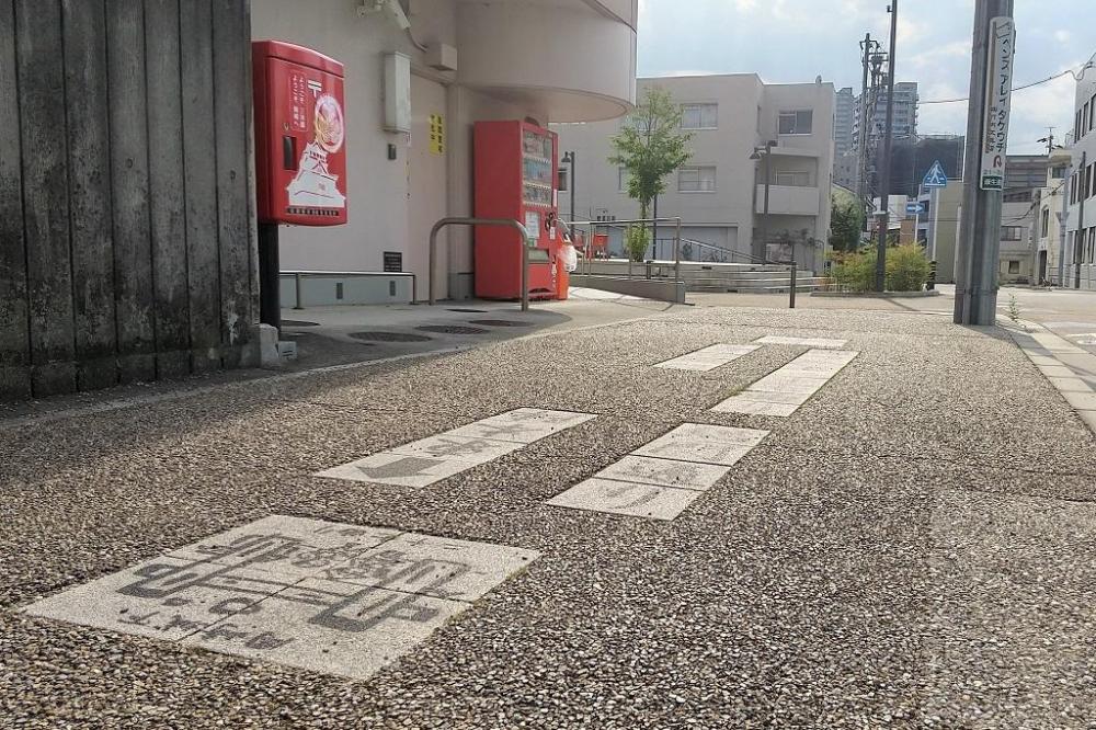 康生郵便局前の旧東海道にはめ込まれた「籠田総門」のプレート