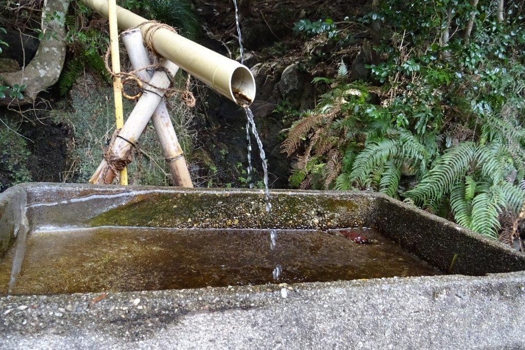 滝の上から引いたパイプで水汲みが出来るようになっています。