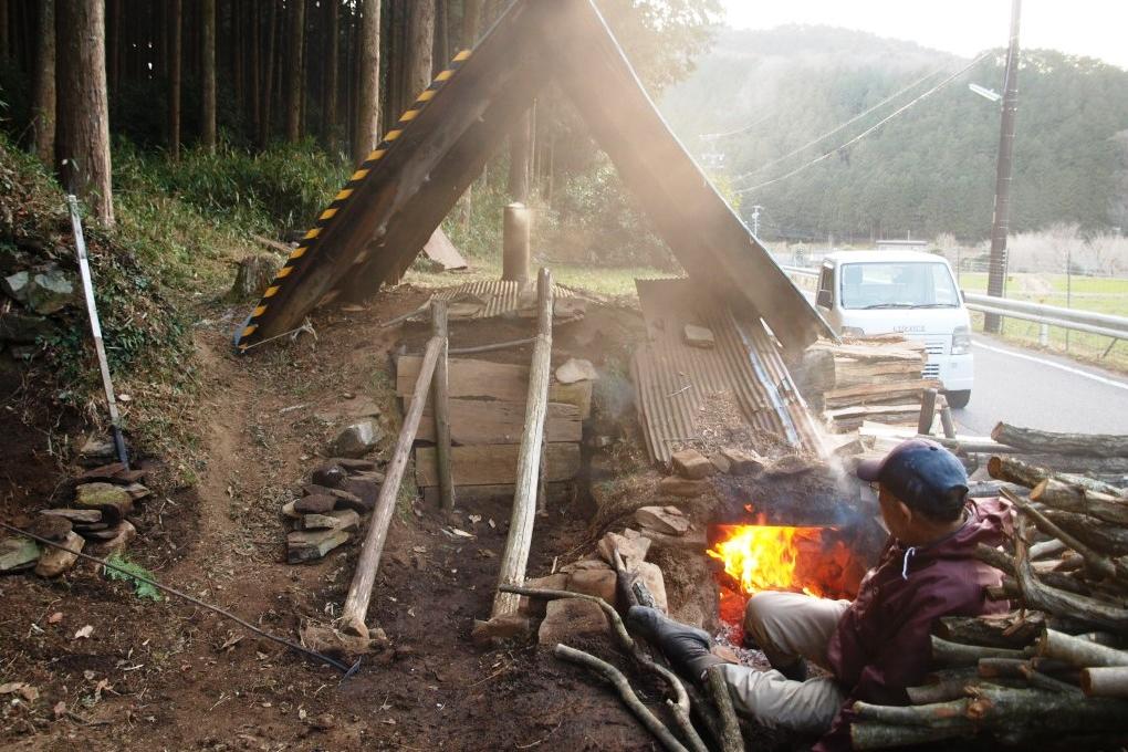 火入れの様子（木を出し入れする中央の口とは別に、右側の焚口があるのが特徴）