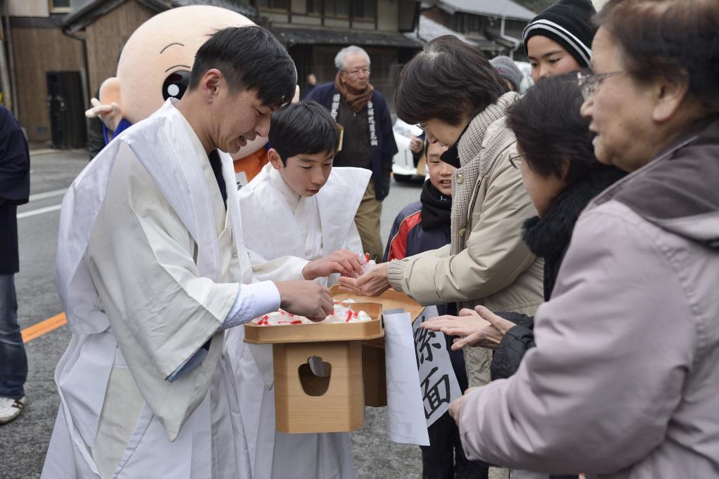 行列中に沿道の方へ縁起物を配ります。