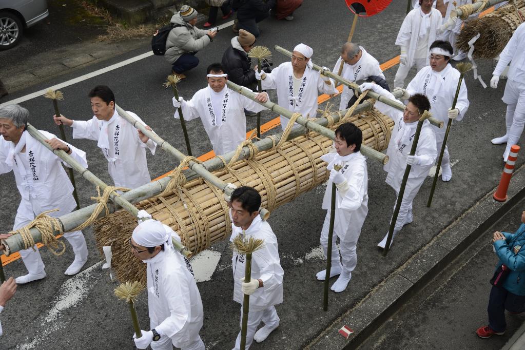 巨大な松明を8人がかりで担ぎます。